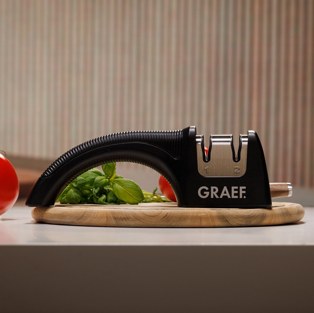 GRAEF Messerschärfer auf Holzbrett in der Küche, Basilikum und Tomaten im Hintergrund