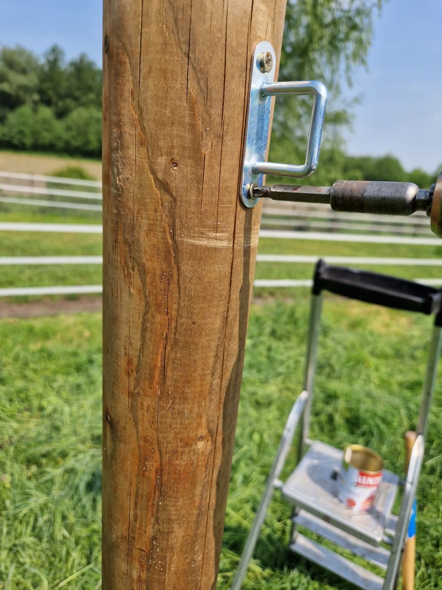 Riemenkrampe am Holzpfosten zur Abspannung eines Sonnensegels