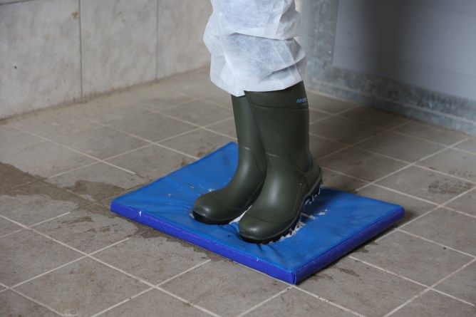 Desinfektions-Matte im Hygienebereich mit Schutzkleidung